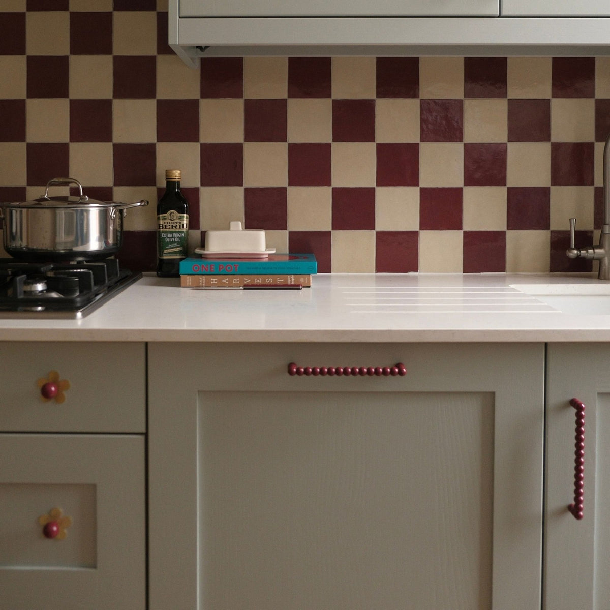 Burgundy D Bar BOBBIN pull installed on kitchen cupboards.